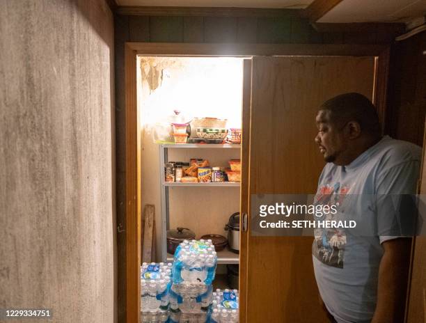 Cleophus Mooney looks at cases of water in his home in Flint, Michigan, October 22,2020. Flint, Michigan residents are still working through a water...