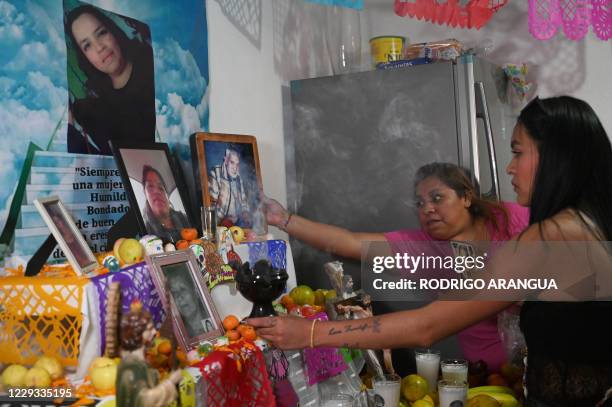 Relatives of Alma Delia Romero Sanchez, who died from Covid-19, prepare an altar in her honor for the Day of the Dead, in Mexico City, on October 25,...