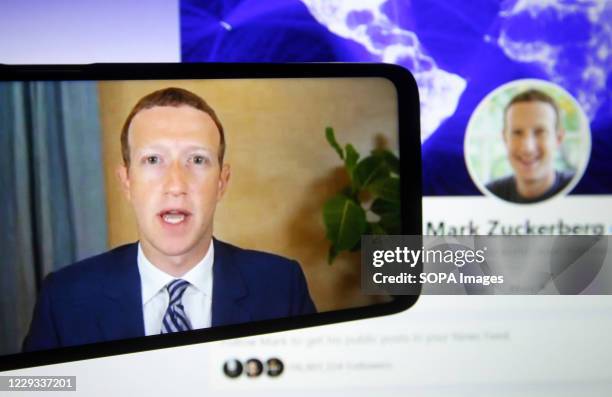 In this photo illustration, Facebook CEO Mark Zuckerberg seen on a mobile screen as he remotely testifies during the hearing of U.S. Senate Committee...