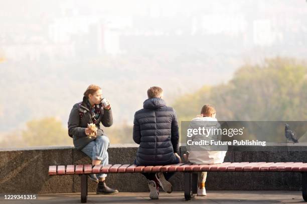 People sit on the bench overlooking the right bank of the Dnipro River, Kyiv, capital of Ukraine.- PHOTOGRAPH BY Ukrinform / Future Publishing