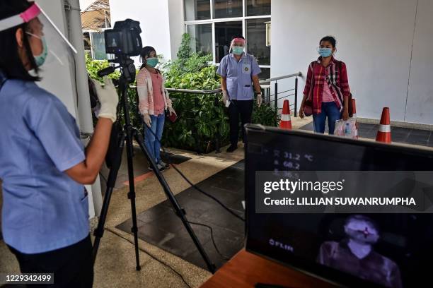 People line up to have their temperatures taken as a preventive measure against the spread of the COVID-19 novel coronavirus at the Ministry of...