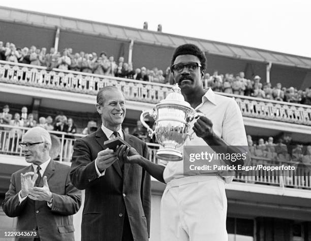 West Indies captain Clive Lloyd holds the Prudential World Cup as he is presented with his winner's medal by HRH Prince Philip after the World Cup...