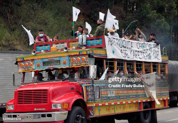 Former members of guerrilla group FARC-EP wave flags during a march to Bogotá to demand compliance of peace deal signed with national government on...