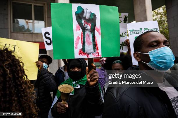 Man holds a placard during a protest where Nigerian community in Madrid demonstrate demanding the end of SARS , the end of police brutality and the...