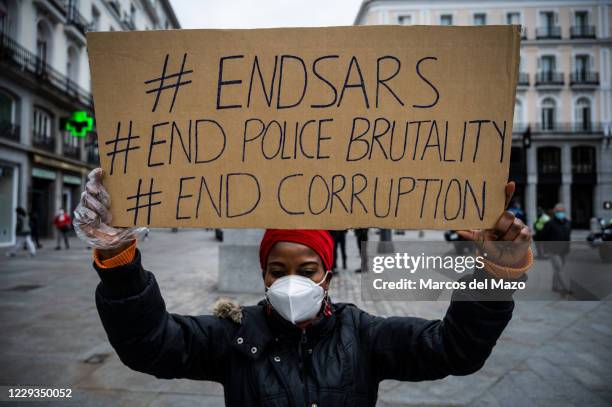 Woman holds a placard during a protest where Nigerian community in Madrid demonstrate demanding the end of SARS , the end of police brutality and the...