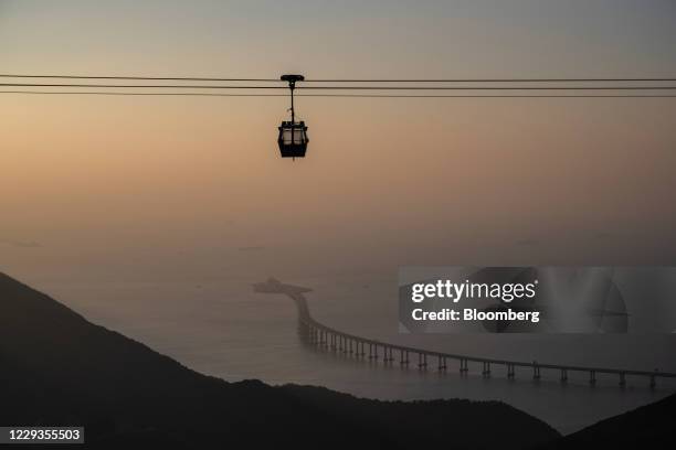 Ngong Ping cable car travels past the Hong Kong-Zhuhai-Macau Bridge in Hong Kong, China, on Saturday, Oct. 3, 2020. Hong Kong's economy is showing...