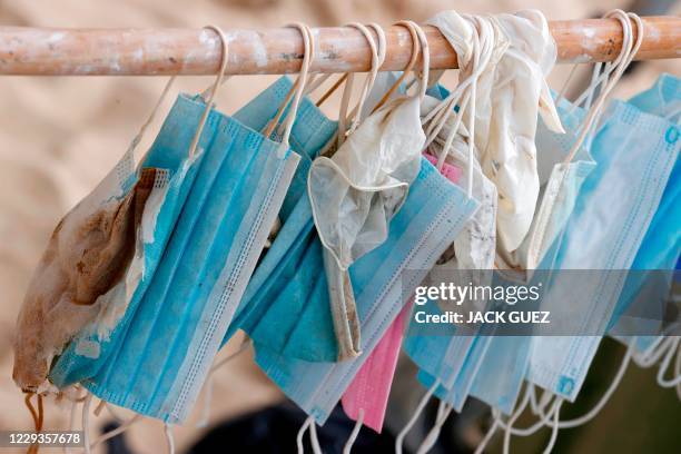 Face masks are gathered by Israeli volunteers taking part in a mass beach clean up during a one-day operation launched by some 20 Israeli...