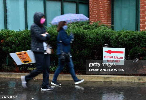 Voters leave after dropping off their ballot during early voting in Allentown, Pennsylvania on October 29, 2020.