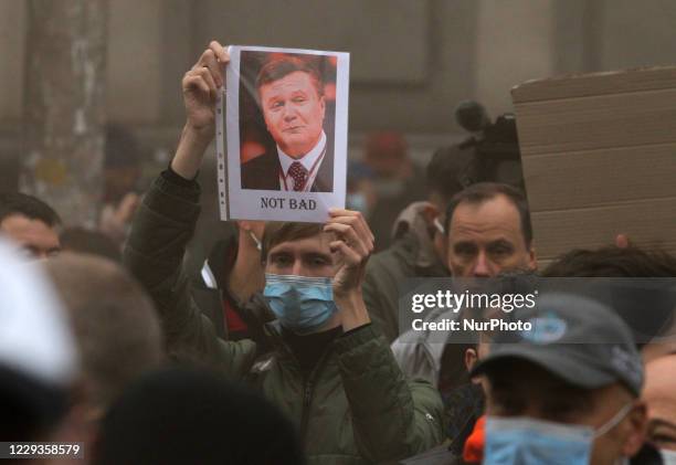 Man holds a placard with an image of former Ukrainian President Viktor Yanukovich during a protest against the cancellation of criminal liability for...