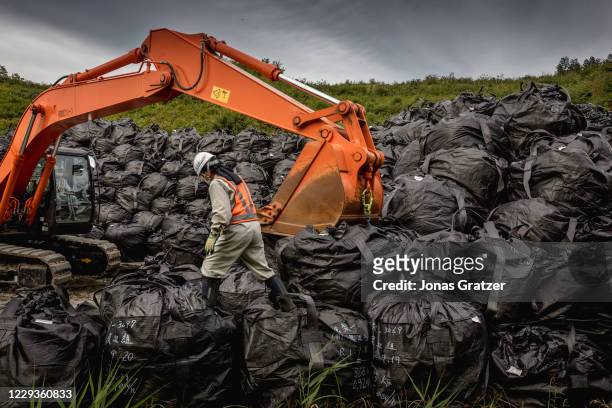 Radioactive soil has been decontaminated from the land around Fukushima and packed in black bags that are stacked on piles while waiting to be...