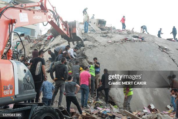 Volunteers clear rubbles as they search for survivors in a collapsed building after a strong earthquake struck the country's western coast and parts...