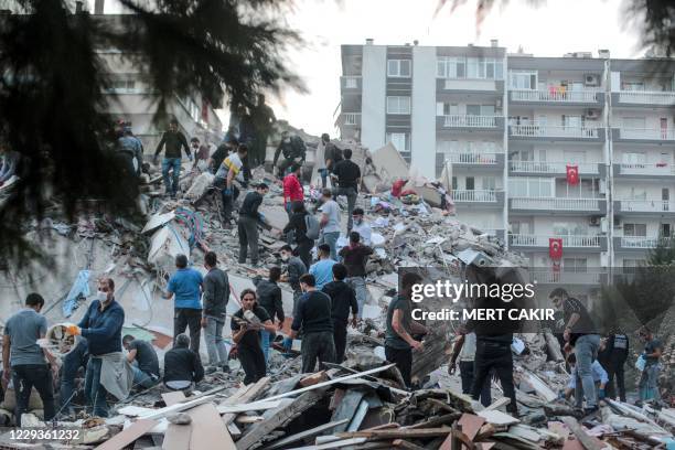 Volunteers clear rubbles as they search for survivors in a collapsed building after a strong earthquake struck the country's western coast and parts...