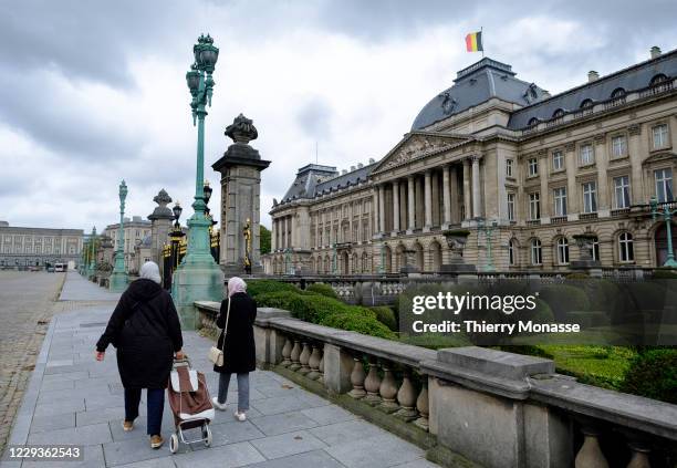 Two women walk with a shopping trolley in front of the Royal Palace, on October 28 in Brussels, Belgium. On October 29, the Interministerial...