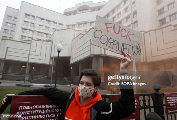 Protester wearing a face mask holds a placard during the demonstration outside the Constitutional Court in Kiev. On October 27, the Constitutional...