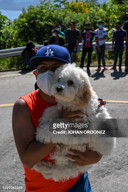 Man and his dog attend the stage 8 of the Vuelta a Guatemala cycling race in San Pablo La Laguna, 165 km west of Guatemala City, on October 30, 2020....