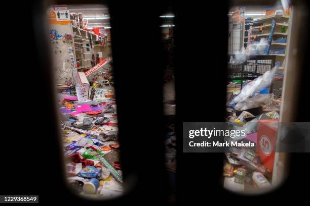 Merchandise lays strewn on the floor after looting as seen through a boarded up door of a discount store on October 30, 2020 in Philadelphia,...