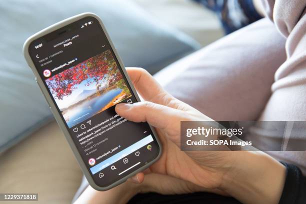 In this photo illustration a woman holds the new iPhone 12 in her hands while checking the Instagram feed.