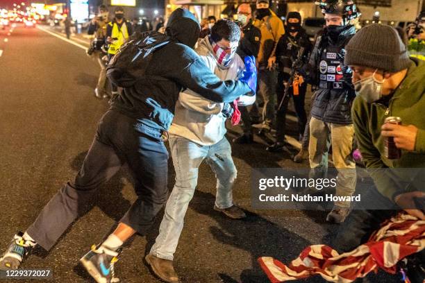 Black Lives Matter activists clash with a right-wing protester after the crowd attempted to burn an American flag on October 30, 2020 in Vancouver,...