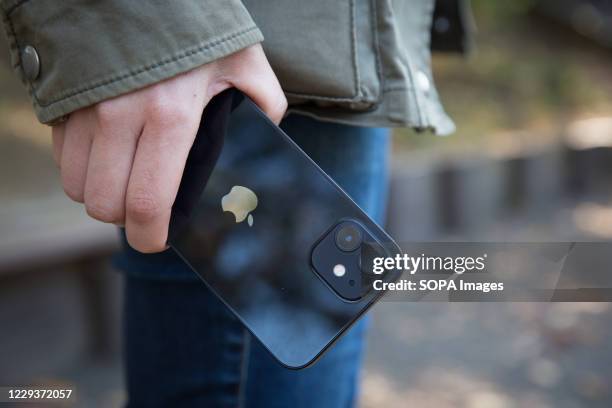 In this photo illustration a woman holds the new iPhone 12 in her hand.