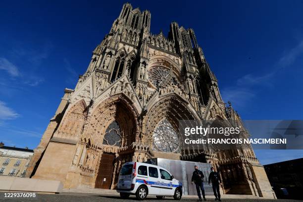 City Police stand guard outside Notre-Dame de Reims cathedral in Reims, eastern France, on October 31, 2020 as France's security forces are on high...