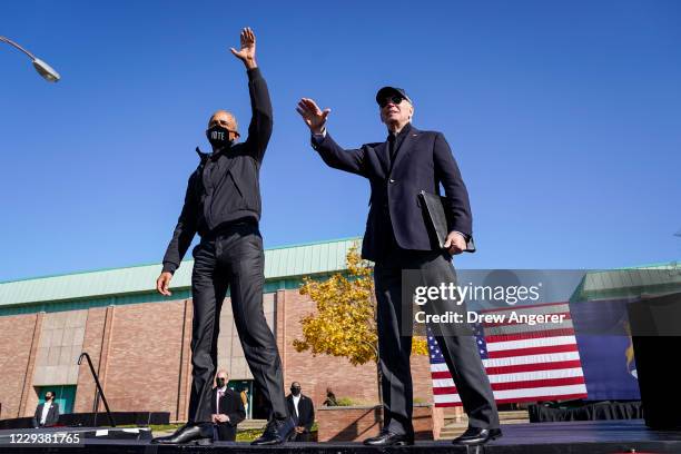 Former U.S. President Barack Obama and Democratic presidential nominee Joe Biden wave to the crowd at the end of a drive-in campaign rally at...