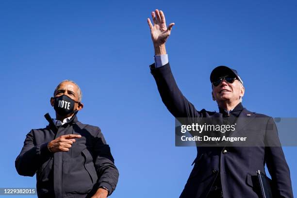 Former U.S. President Barack Obama and Democratic presidential nominee Joe Biden wave to the crowd at the end of a drive-in campaign rally at...