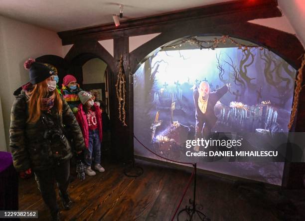 Visitors watch a movie depicting the awakening of a vampire during a special tour of Bran Castle organized for Halloween in Bran village October 31,...