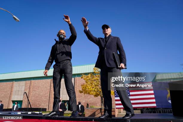 Former U.S. President Barack Obama and Democratic presidential nominee Joe Biden wave to the crowd at the end of a drive-in campaign rally at...