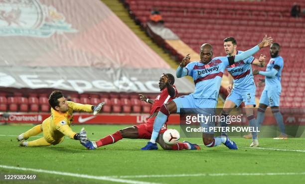 Liverpool's Senegalese striker Sadio Mane slides into and fouls West Ham United's Polish goalkeeper Lukasz Fabianski during a goal-mouth scramble in...