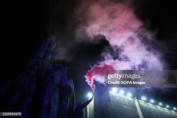 Protester holding a pink buring flare stands on a monument during the demonstration. The Polish Constitutional Court in its new, politically chosen...