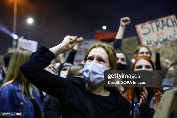 Protester wearing a face mask hold up her fist during the demonstration. The Polish Constitutional Court in its new, politically chosen courthouse...