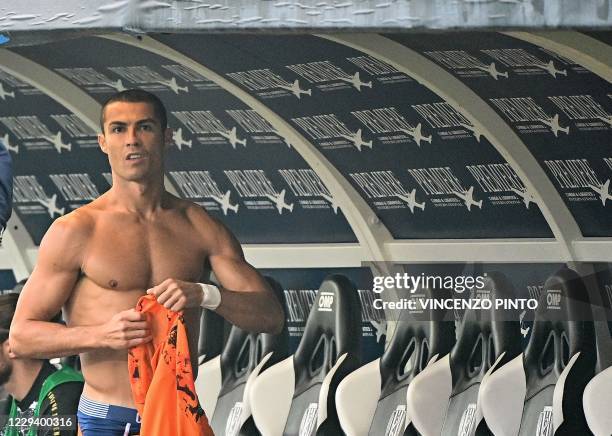 Juventus' Portuguese striker Cristiano Ronaldo puts on his shirt as he prepares to come onto the field during the Italian Serie A football match...