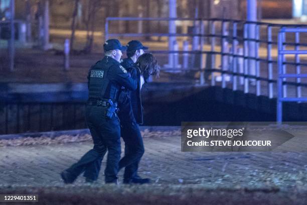 Police officers detain a suspect near the National Assembly of Quebec, in Quebec City, early on November 1 after two people were killed and five...