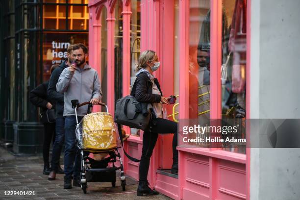 People line up to enter an Oliver Bonas store in Islington on November 1, 2020 in London, United Kingdom. To curb rising rates of covid-19, the...