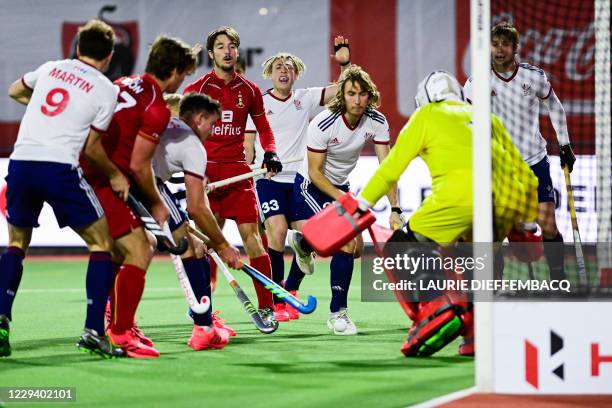 Belgium's Antoine Kina, Britain's Jacob Draper and Britain's goalkeeper George Pinner fight for the ball during a hockey game between the Belgian Red...