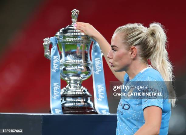 Manchester City's English defender Alex Greenwood touches the trophy as she walks past after winning the English Women's FA Cup final football match...