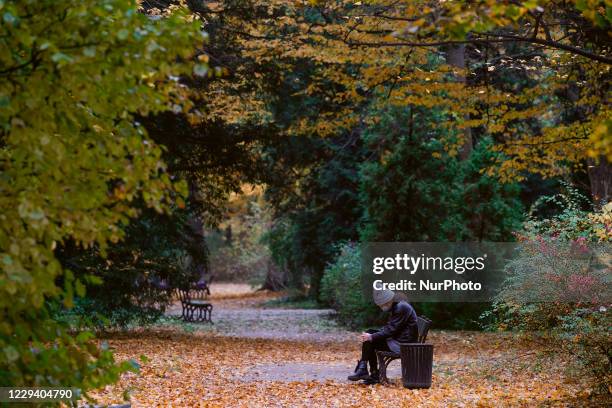 Woman is seen sitting on a bench n the Royal Baths park in Warsaw, Poland on October 31, 2020. Arks are one of the few places where people can find...