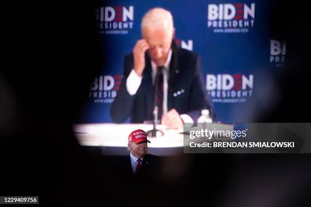 President Donald Trump watches a video of his opponent former US Vice President Joe Biden during a Make America Great Again rally at Miami-Opa Locka...