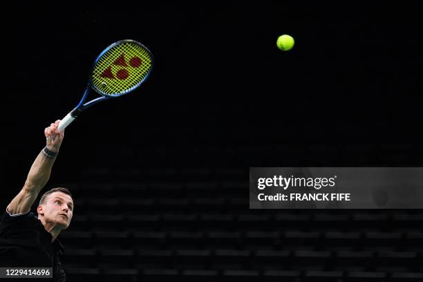 Hungary's Marton Fucsovics serves the ball to Croatia's Borna Coric during their men's singles first round tennis match on day 1 at the ATP World...