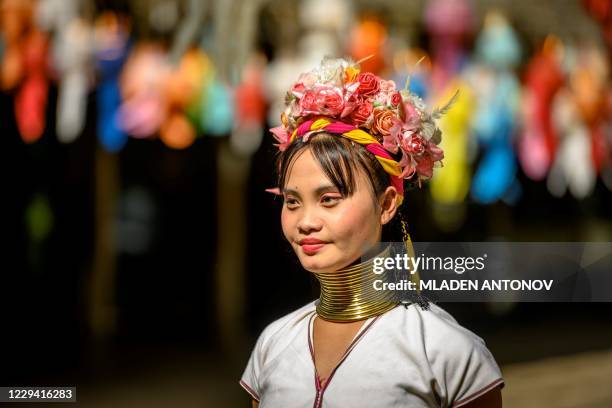 Long neck Karen woman walks in Baan Tong Luang hill tribes village situated some 30 km west of Chiang Mai on November 2, 2020. - Created as a tourist...