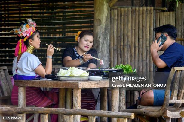 Hill tribe people eat their lunch in Baan Tong Luang hill tribes village situated some 30km west of Chiang Mai on November 2, 2020. - Created as a...