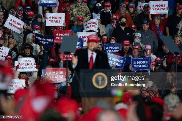 Attendees hold up signs as U.S. President Donald Trump speaks during a campaign rally in Rome, Georgia, U.S., on Sunday, Nov. 1, 2020. After striding...