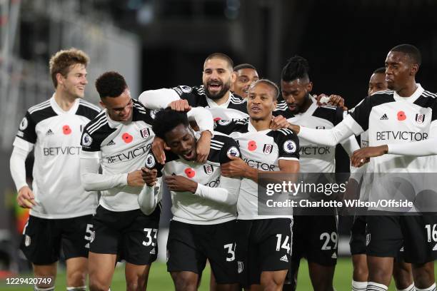 Ola Aina of Fulham is chased by the entire team as he celebrates scoring their 2nd goal during the Premier League match between Fulham and West...