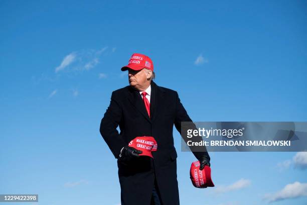 President Donald Trump throws hats to supporters during a Make America Great Again rally at Wilkes-Barre Scranton International Airport November 2 in...