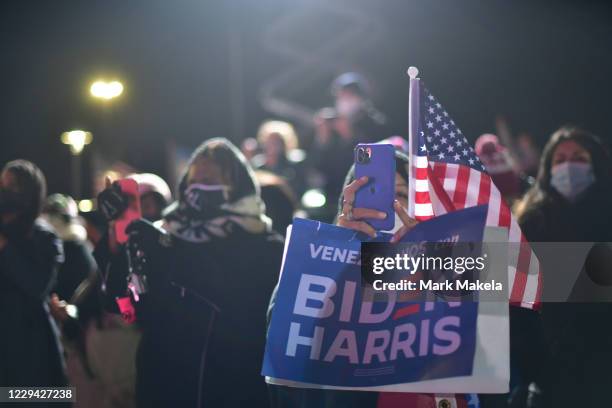 Supporters photograph Democratic vice presidential nominee Sen. Kamala Harris speaking at a drive-in election eve rally on November 2, 2020 in...