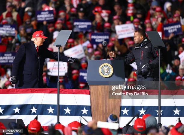 John James, a Republican U.S. Senate candidate fist bumps with U.S. President Donald Trump during a campaign rally on November 2, 2020 in Traverse...