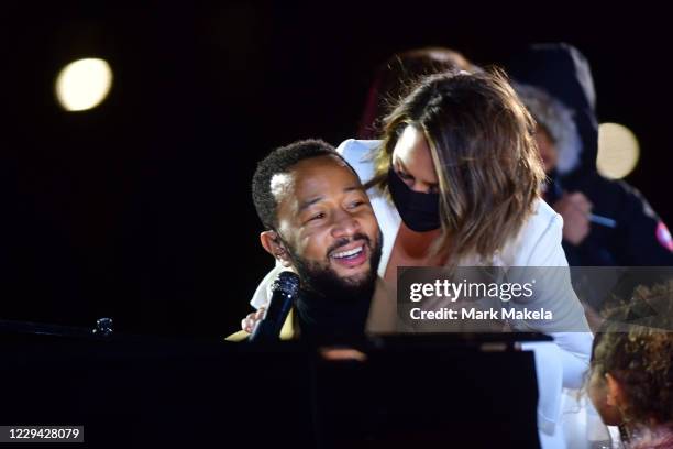 Singer John Legend is joined onstage by his wife, Chrissy Teigen, and daughter while performing before Democratic vice presidential nominee Sen....