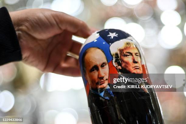 Vendor shows a traditional Russian wooden nesting doll, Matryoshka doll, depicting Russia's President Vladimir Putin and US President and Republican...