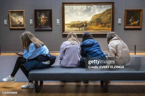 Visitors look at exhibits in The Rijksmuseum in Amsterdam on November 3, 2020. - The Netherlands' cabinet is considering additional coronavirus...