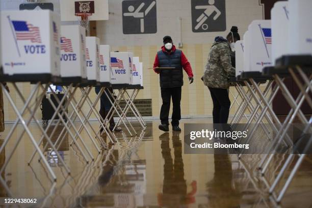 Voter walks to a voting booth to cast ballot their ballot at a polling location in Southfield, Michigan, U.S., on Tuesday, Nov. 3, 2020. American...